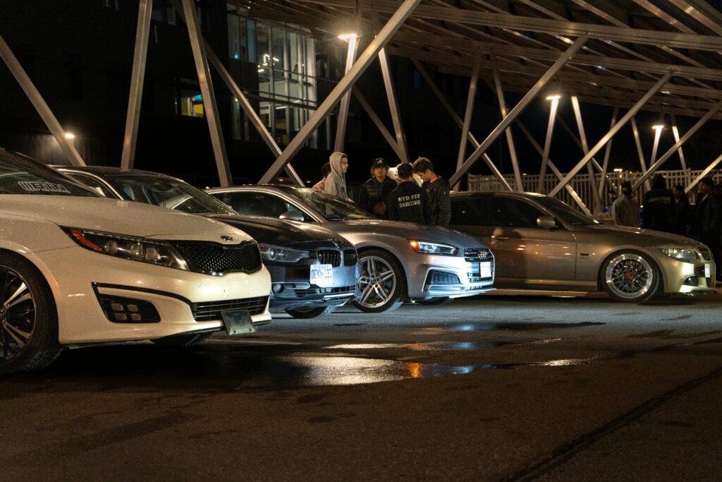 Captivating night scene of a car meetup in Waterloo with cars lined up under city lights.