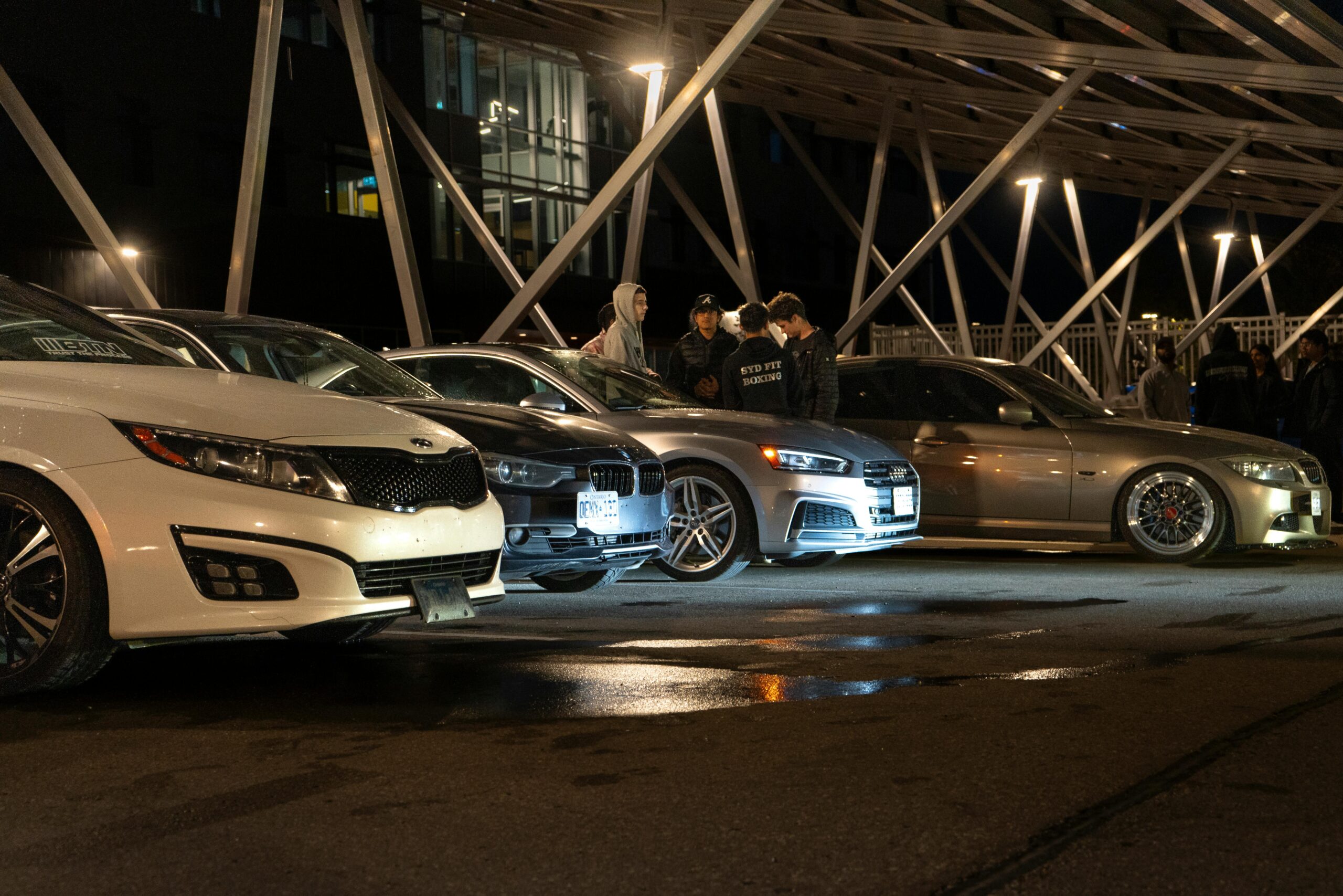 Captivating night scene of a car meetup in Waterloo with cars lined up under city lights.